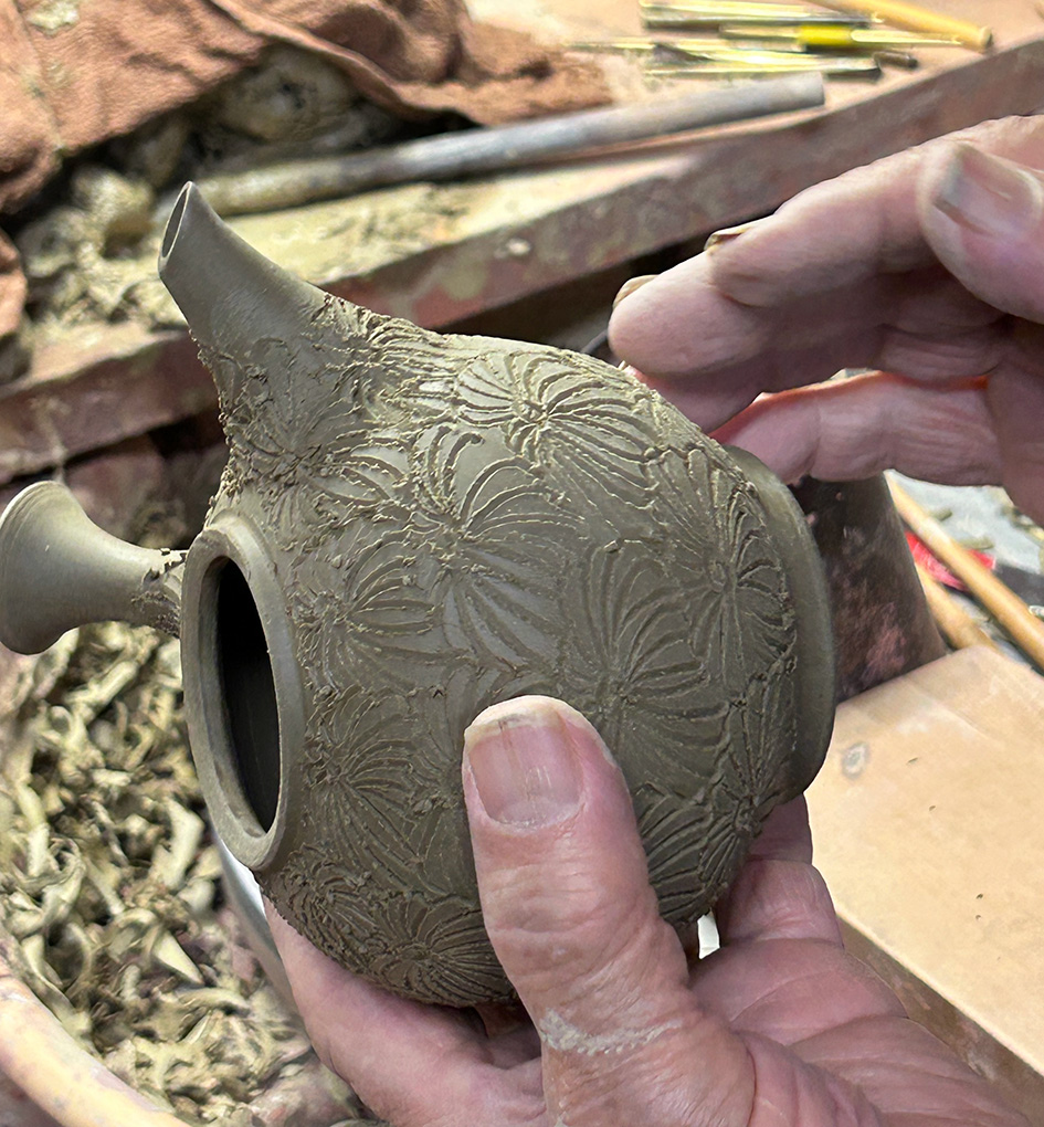 Konishi Yohei hand engraving a chrysanthemum teapot