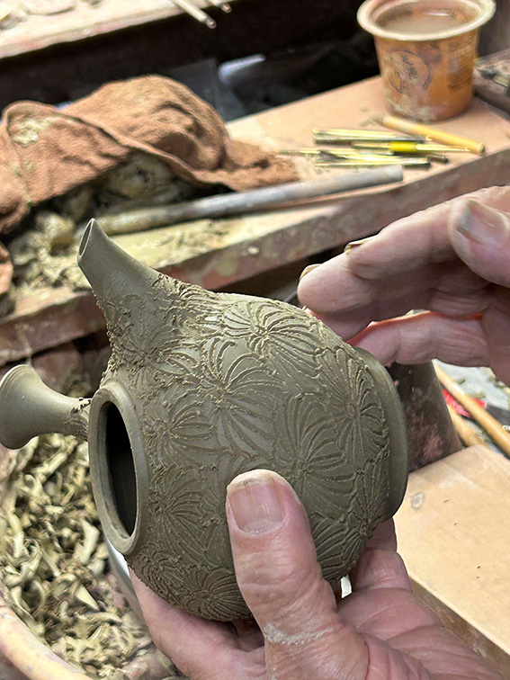 Master potter Konishi Yohei engraving a handmade Tokoname kyusu teapot